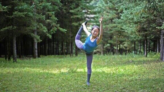 年轻的亚洲女性在森林里练习瑜伽