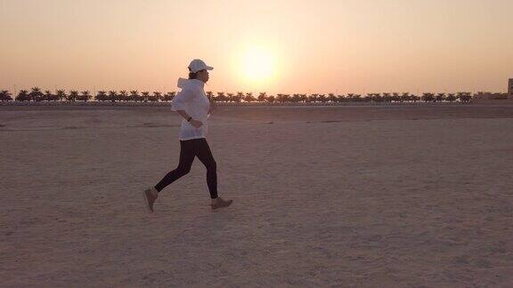 日落时分在沙滩上慢跑的女人