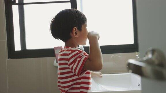 亚洲男孩刷牙是为了防止蛀牙孩子们吃完饭后要注意口腔卫生