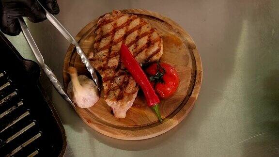 厨师把炸肉、西红柿和大蒜放在盘子上的特写镜头