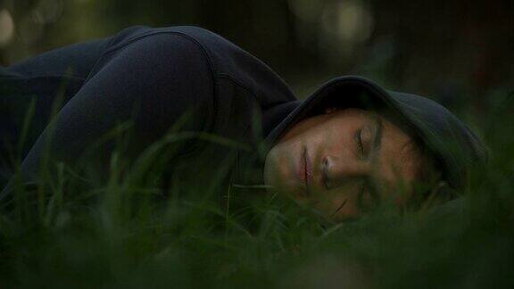 无家可归的男性睡在公园的草地上贫困和社会问题