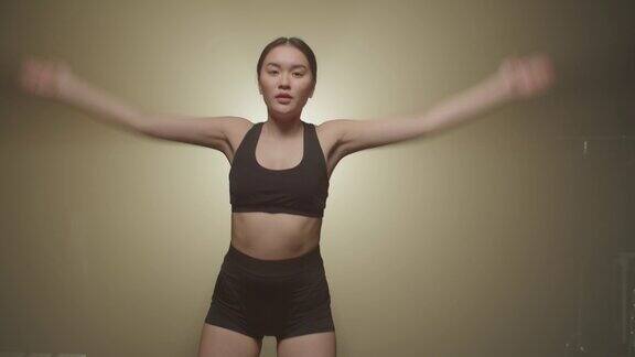 积极主动的运动适合亚洲女性在健身房做开合跳锻炼