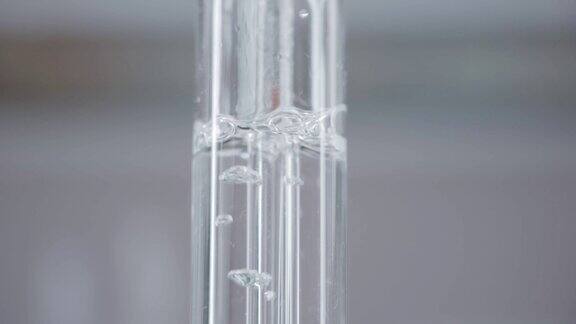 明亮的实验室玻璃烧瓶水在烧瓶里沸腾化学反应垂直的全景摄像机从下往上移动4k