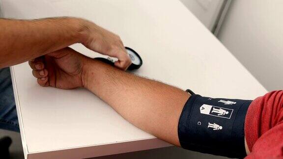 医生为男性病人测量血压