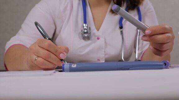 医生拿着胰岛素笔给糖尿病患者写处方