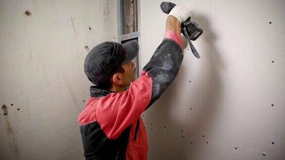 施工人员使用电钻在墙上统一安装面板