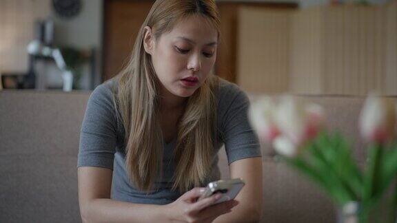 苦恼的亚洲妇女在查看手机信息后感到不安和担忧