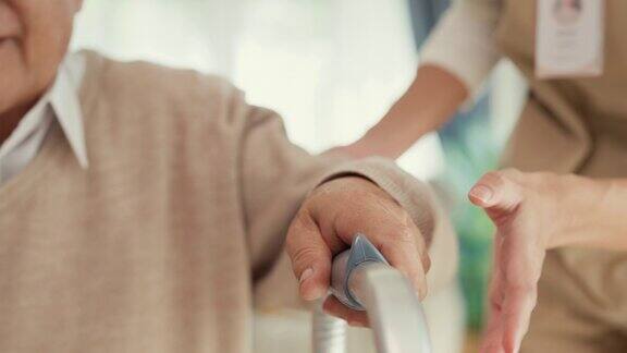 特写年轻的亚洲女性护理人员教老男性步行使用助行器照顾握着老人的手在家里