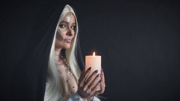 死者灵魂的女祭司持有燃烧的蜡烛并举行仪式迎接死者