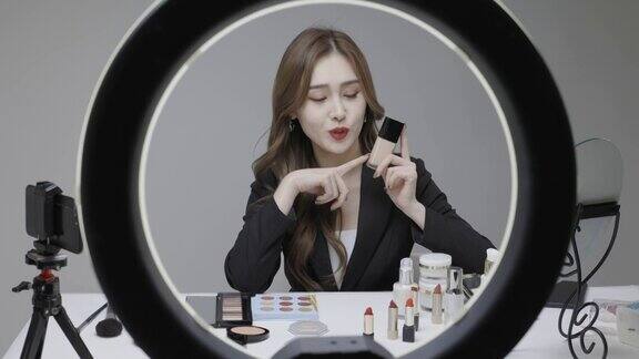 一位穿着黑色西装的美丽韩国女主人在网上卖化妆品