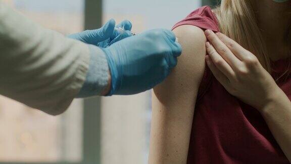 在健康诊所医生正在给一位女性病人注射疫苗