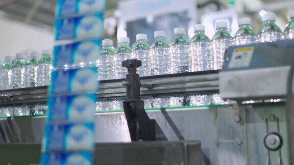 矿泉水厂生产线将纯泉水灌装成瓶、罐