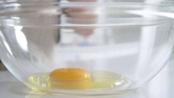 在家里的厨房里把一个鸡蛋直接打到玻璃碗里就可以做蛋糕了