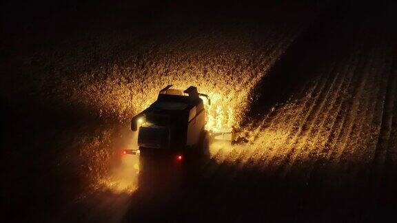 无人机拍摄的联合收割机夜间在农田收割玉米的前灯
