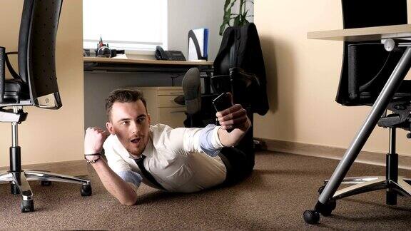 一个年轻人躺在办公室中间的地板上自拍60fps
