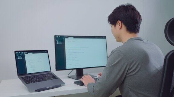 亚洲男性程序员在办公室的电脑上编程