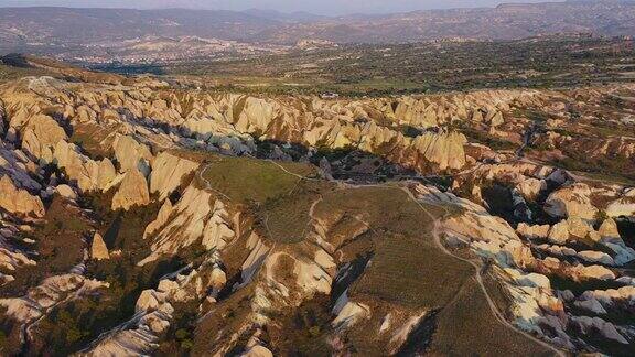 卡帕多西亚五彩缤纷的岩层上的风景日落的空中4k镜头