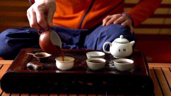 在中国传统茶道上一名男子用茶壶倒普洱茶一套饮茶设备
