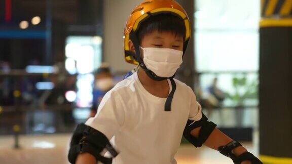 亚洲男孩只是在室内练习轮滑和直排轮滑