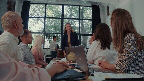美丽的白人首席执行官女商人进入办公室团队会议与多种族同事慢镜头交谈