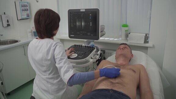 女医生在心脏病诊所用现代化设备给病人做心脏检查女心脏病专家正在用超声检查病人心脏看着屏幕医疗保健