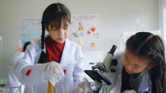 在科学课上一名STEM学校的学生正在用显微镜观察一些东西