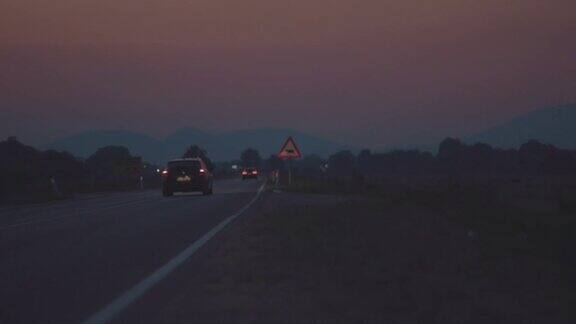 夜晚在山间乡村路上行驶的汽车