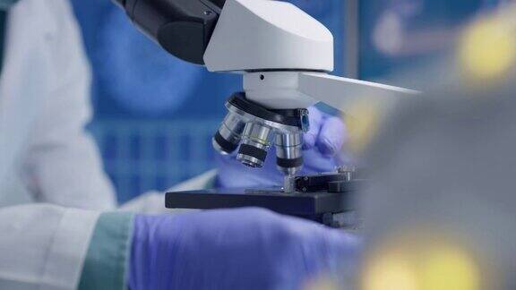 实验室设备显微镜和科学家的手拉近