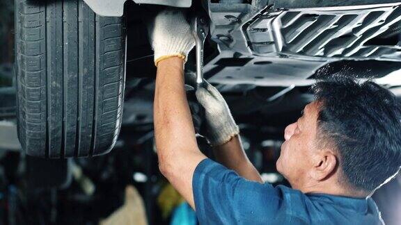 高级机械师在车库检查和修理汽车悬架