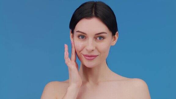 一个大特写一个迷人的欧洲年轻女子用移液管在她的脸颊上涂抹面部护理血清面部精华液广告