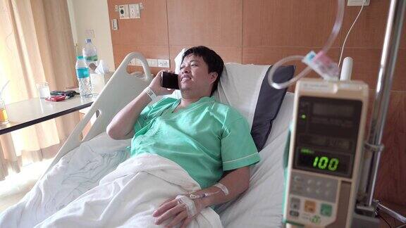 男性亚洲病人在医院病房使用手机