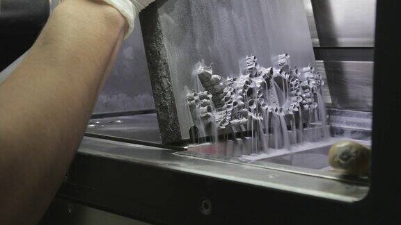 牙科技术人员从铸板上倾倒金属粉末与植牙在3D