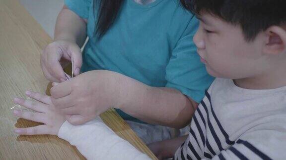 亚洲母亲在家里剪她儿子的指甲