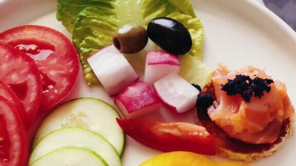 开胃拼盘与鲑鱼黑鱼子酱和切片新鲜蔬菜招待和美食