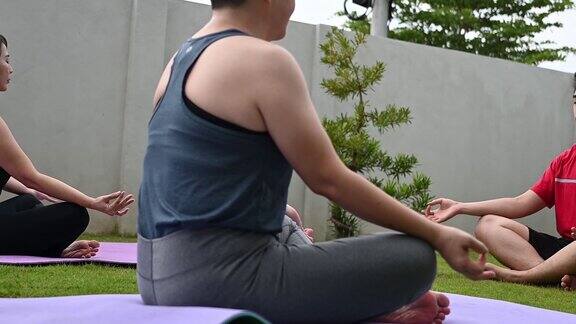 亚洲华人中年妇女练习瑜伽的房子前院上午与朋友