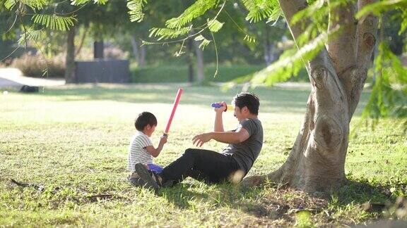 父亲和儿子在公园里打剑户外
