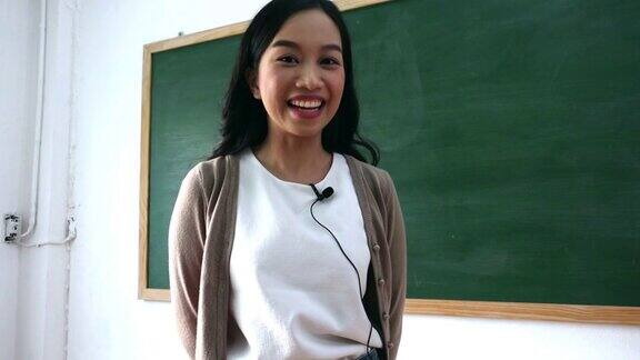 微笑的亚洲女教师的肖像在教室录像现场教学在黑板上解释教训的学生从家里学习在线教育技术理念
