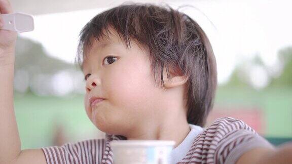 亚洲男孩在自助餐厅吃冰淇淋
