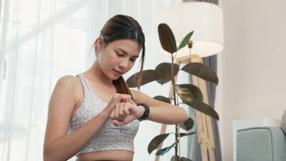 年轻的亚洲女性在锻炼前安装智能手表