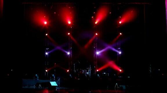 在音乐会舞台上交替闪烁的红色和紫色聚光灯