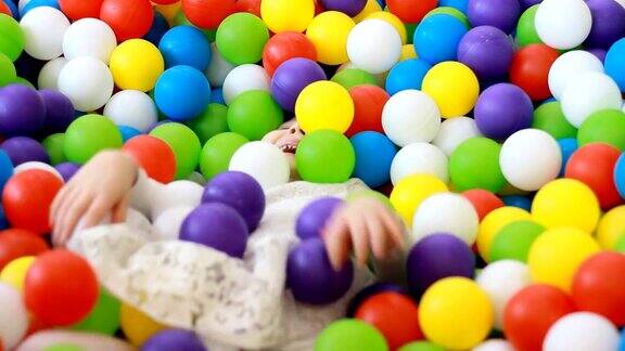 快乐的小女孩在操场上玩着和藏着五颜六色的气球