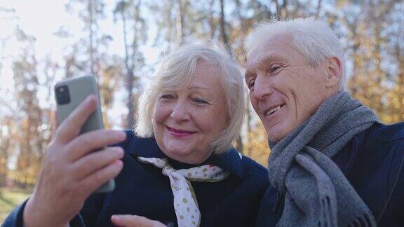 微笑的父母用智能手机给孩子打电话享受在公园散步的乐趣