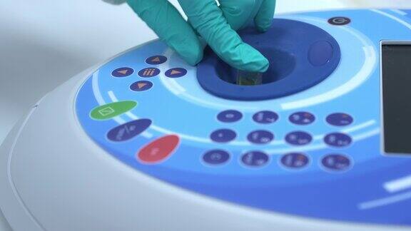 化学家在分光光度计中插入比色皿以分析生物活性化合物