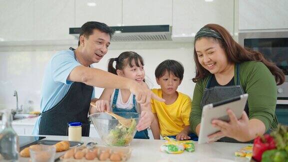 幸福的亚洲家庭在厨房一起烹饪健康