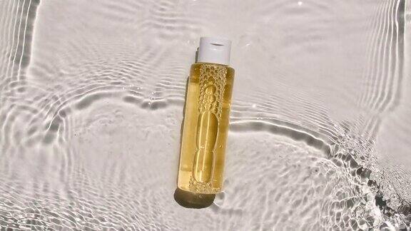 一款保湿护肤品的广告化妆品瓶小瓶在水面上滴药水水反射阳光和阴影缓慢运动的波浪水