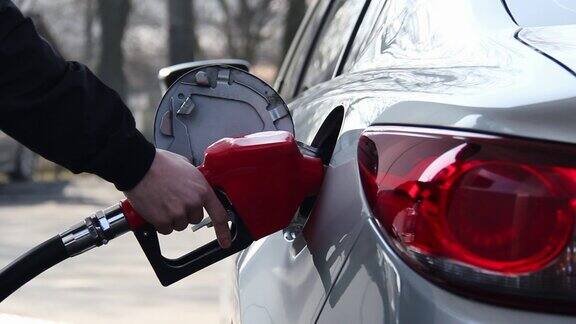 特写的人填补汽油汽油燃料在汽车在加油站