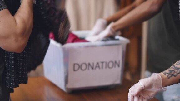 戴着防护手套的志愿者在慈善捐赠中心整理捐赠衣物实时
