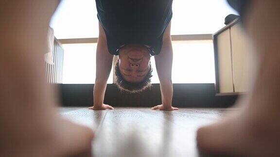 亚洲华人中年妇女在客厅练习瑜伽在周末例行锻炼