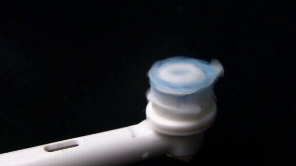 电刷工作和牙膏应用的宏观视频特写显示了喷嘴头部绒毛快速移动口腔卫生