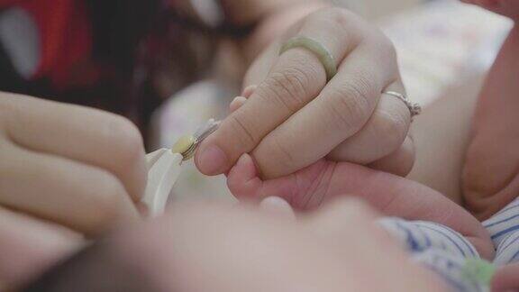 亚洲母亲剪婴儿的指甲